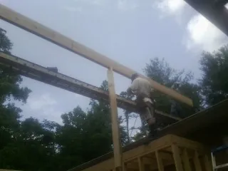 Carpenter setting a ridge beam over a new addition frame — Ice Dam Removal by Roofing Brothers in Romulus