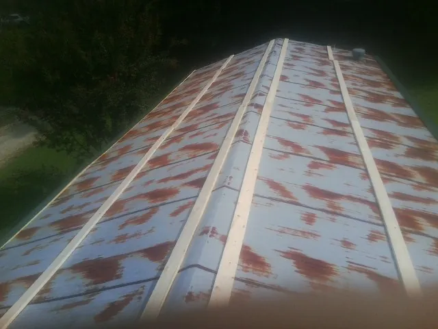 Rusted metal roof panels with new wood purlins before replacement — Storm Damage Roof Repair in Romulus by Roofing Brothers